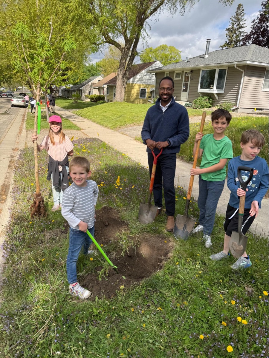 Ayub planting trees with kids